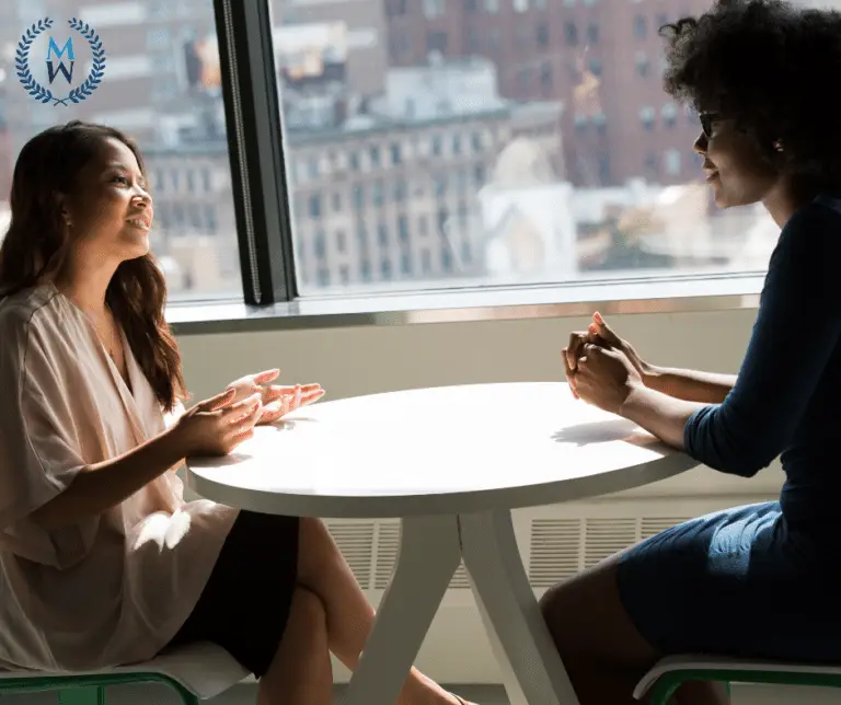 two women talking at a table