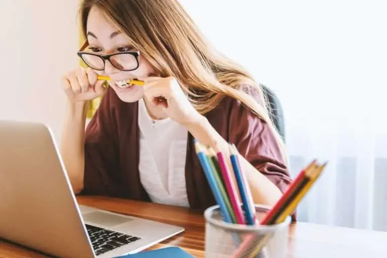 girl biting her pencil in half out of frustration with school