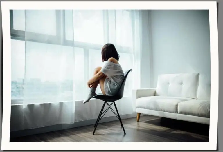 girl sitting in front of window during quarentine