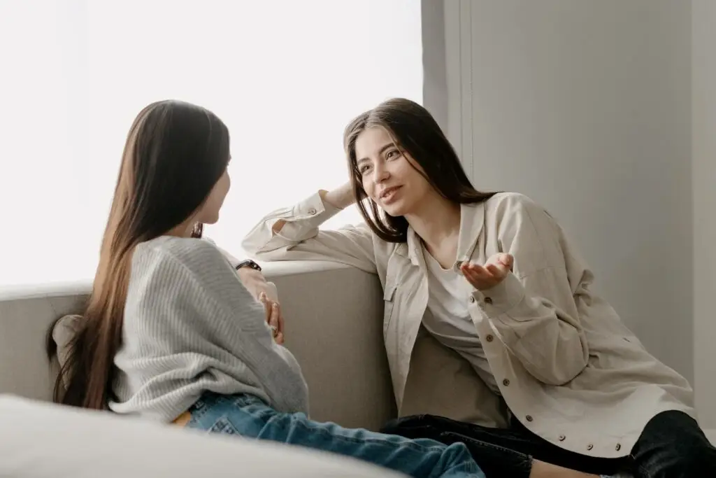 mother talking to her daughter on their living room couch about depression running in their family.