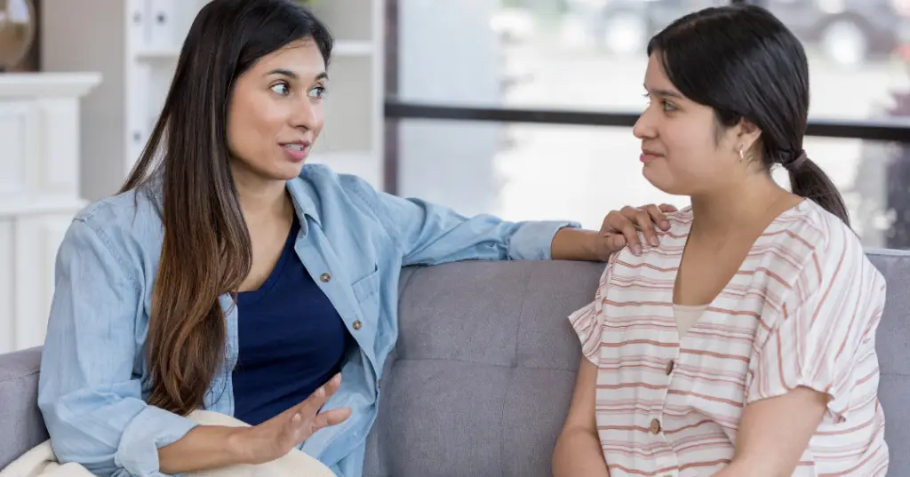 A couple of friends talking on a couch about setting boundaries