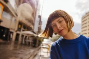 A woman posing for a photo in the middle of a city.