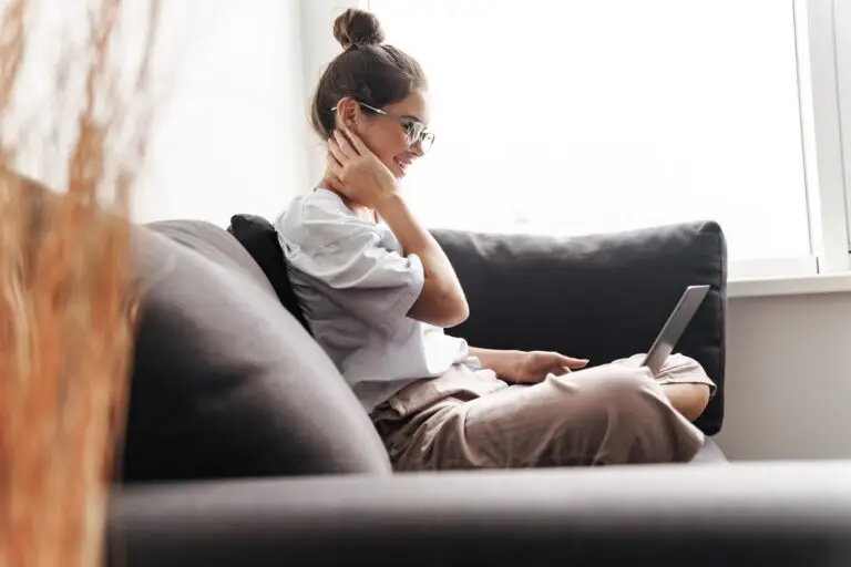 A young woman on her couch with her laptop during an online therapy session for binge eating disorder.