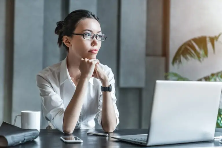 a young professional woman looks off in the distance to identify, challenge and reframe illogical thoughts that come with her anxiety