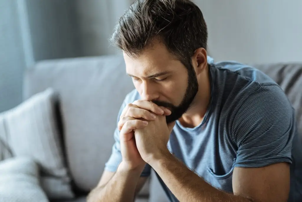 Unhappy young man holding his chin