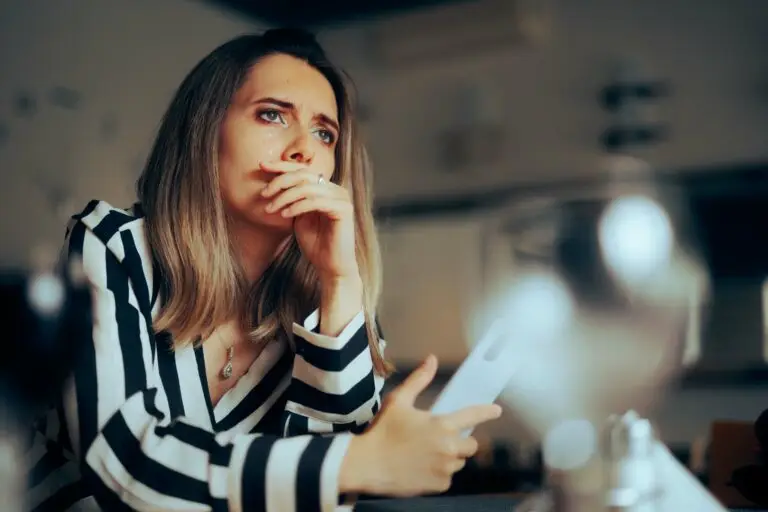 Woman sitting on her couch in distress over her separation anxiety disorder symptoms.