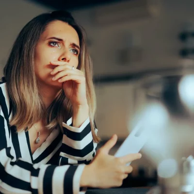 Woman sitting on her couch in distress over her separation anxiety disorder symptoms.