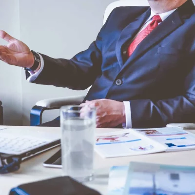 executive sitting at desk making hand gesture