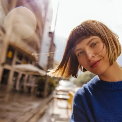 A woman posing for a photo in the middle of a city.